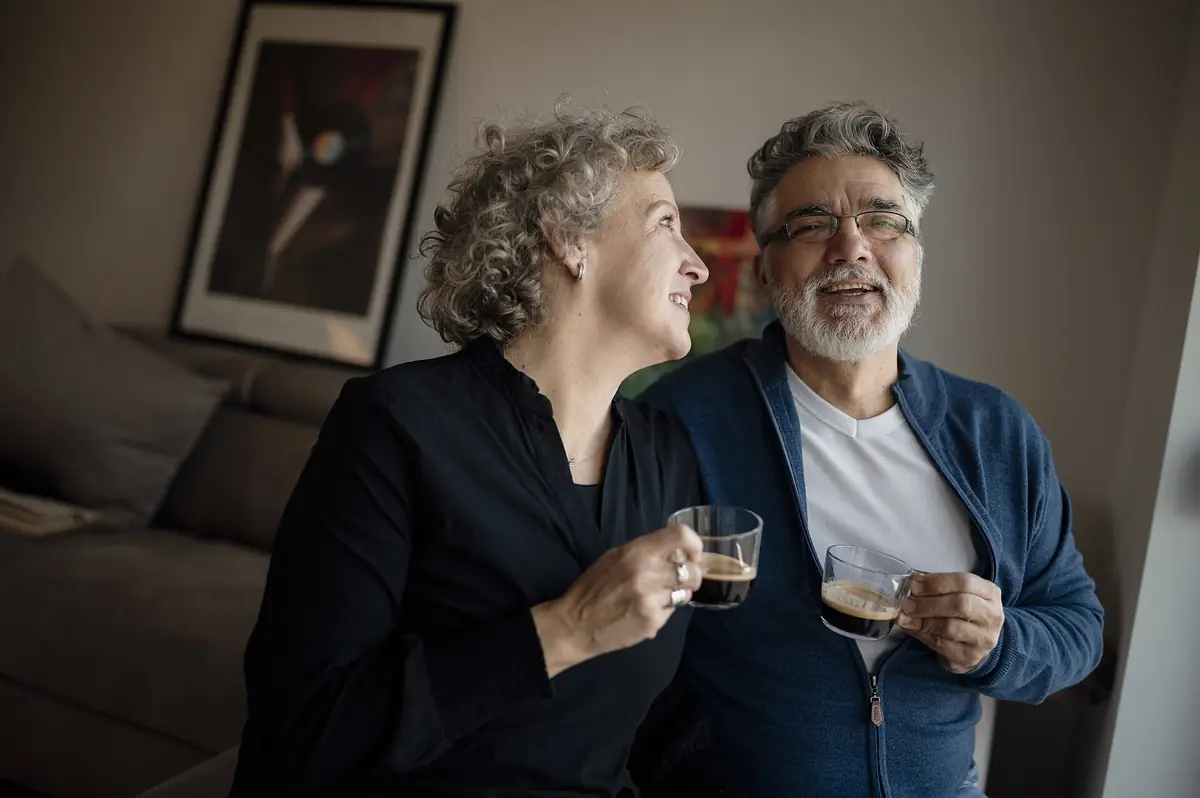A middle-aged couple enjoying coffee together in their living room