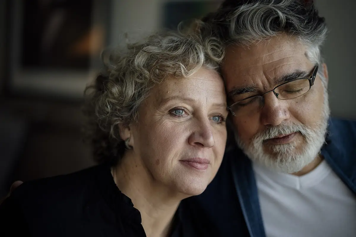 A middle-aged couple sharing a quiet, close moment at home